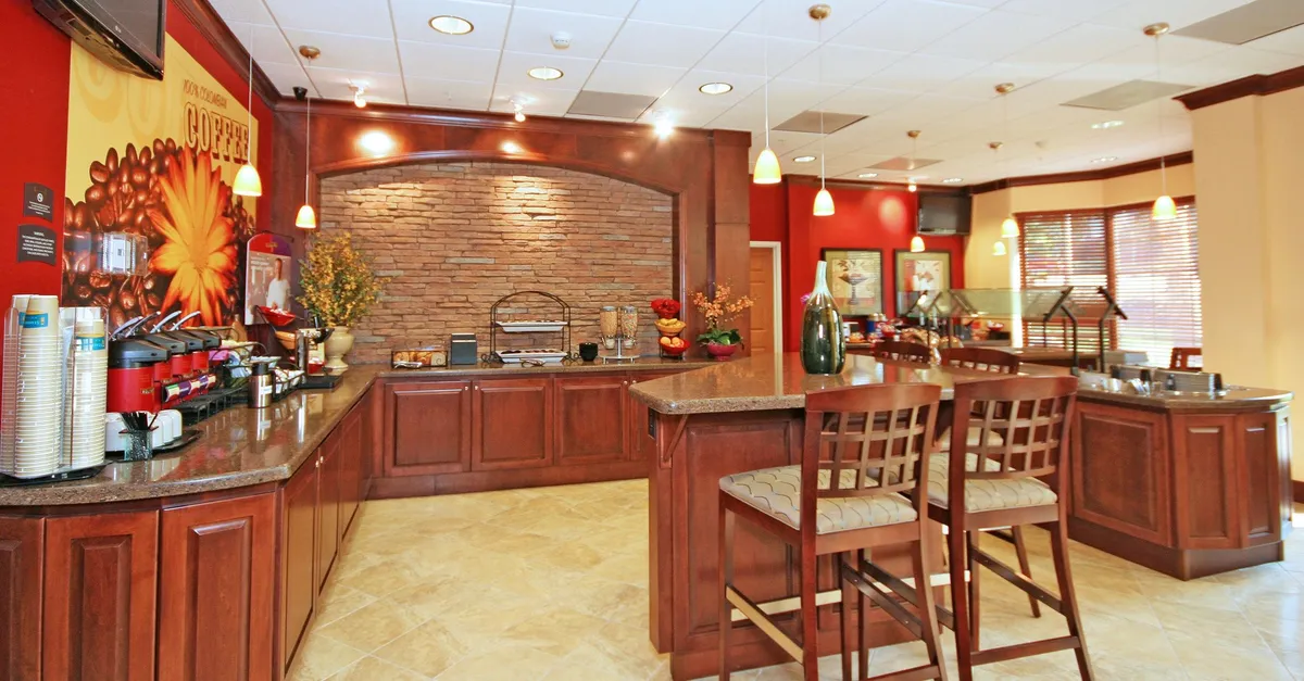 A cozy coffee station set against a decorative stone wall, complemented by a comfortable seating area. The image highlights guests enjoying freshly brewed coffee in a warm, welcoming environment.
